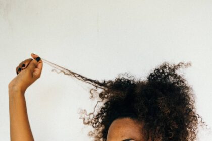 Woman with curly hair pulling strand