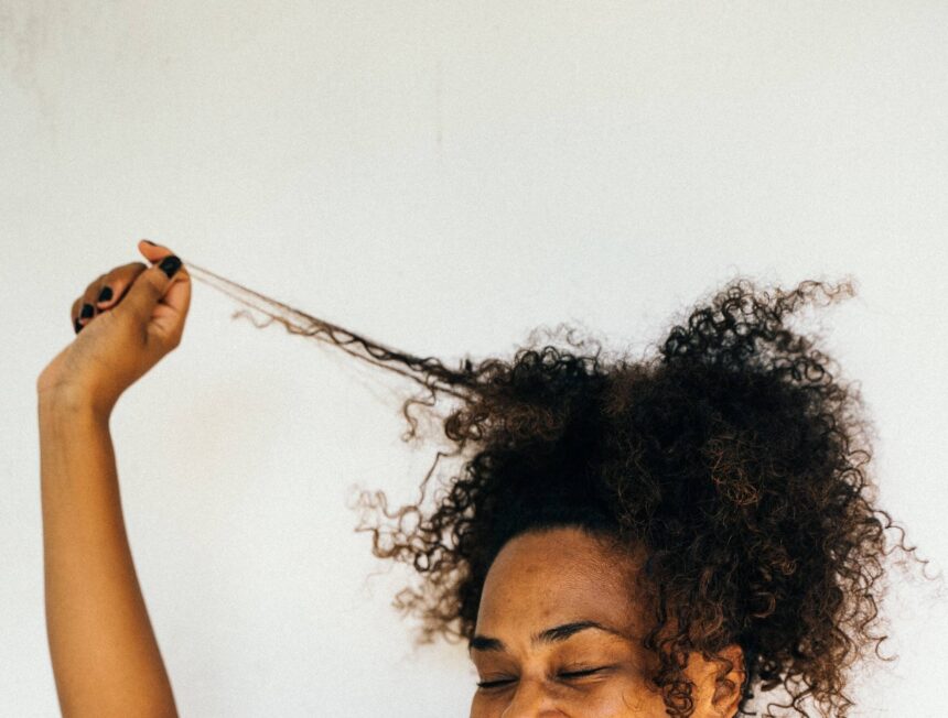 Woman with curly hair pulling strand