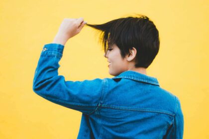 Woman with pixie cut pulling a few strands of hair