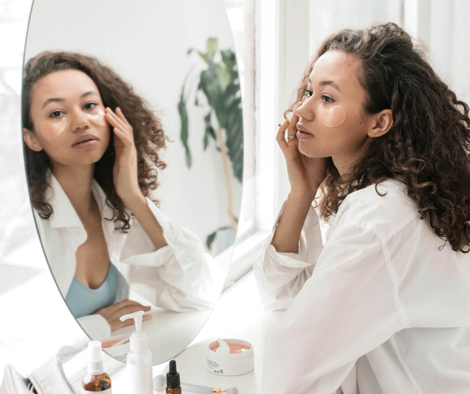 Woman applying cosmetics while looking at herself in the mirror