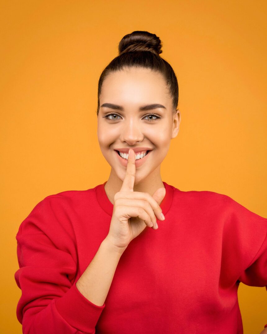 Young lady with hair bun against yellow background