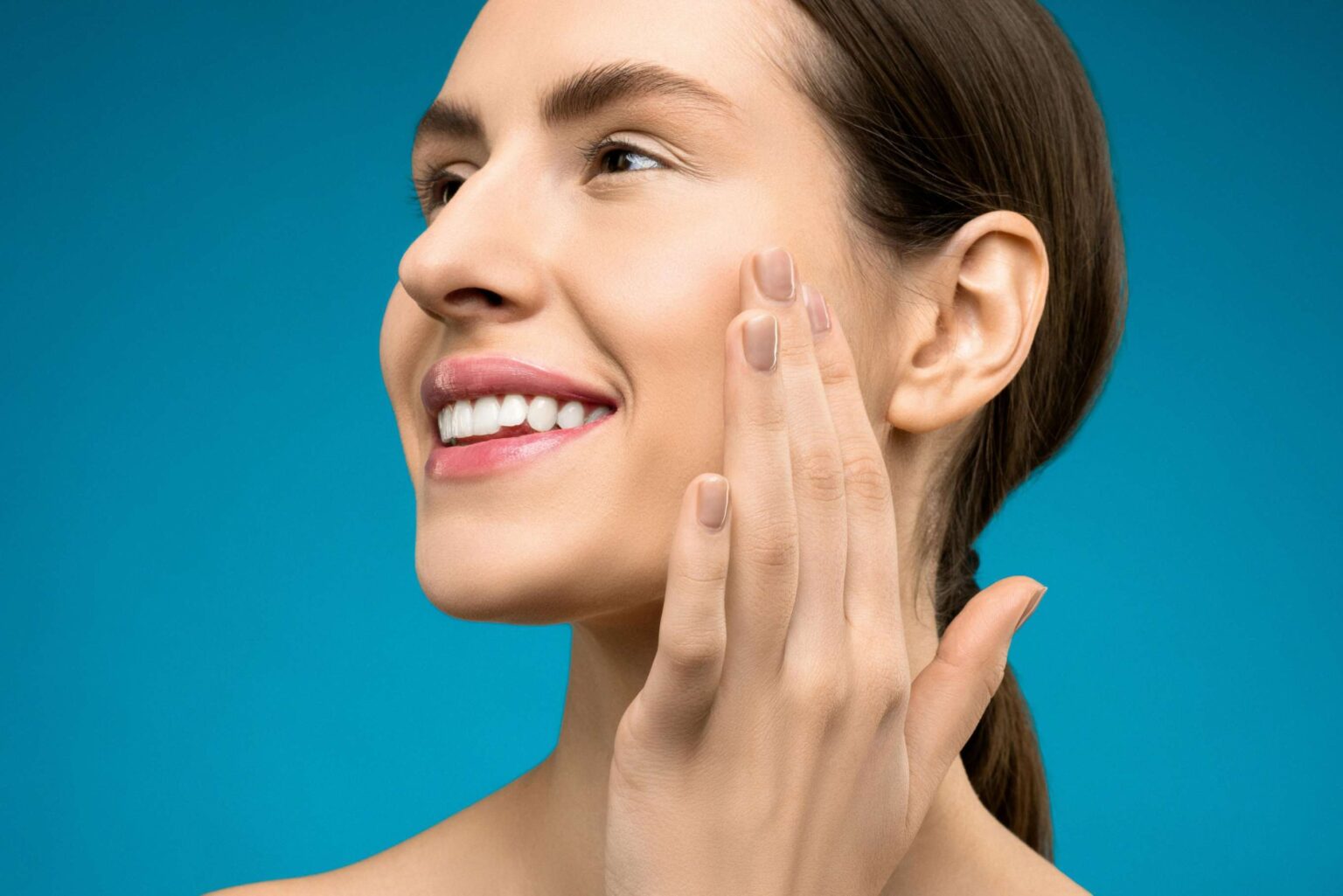 Beautiful woman applying makeup with her hand